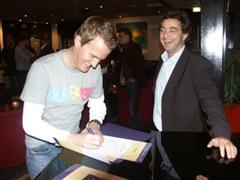 Examenkandidaat Kick van Loon tekent onder toeziend oog van docent Eric Hereijgers het diploma logistiek management