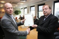 Henk Jonker (rechts) overhandigt het AEO-certificaat aan Bas Janssen van TNT Express Benelux (links)