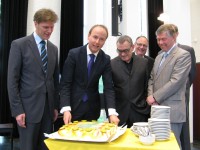 Wethouder Mark Verheijen zet het mes in de taart met daarop de Logistieke Kaart van Nederland 2010. Links van Verheijen, wethouder Jan Loonen van Venray. Gedeputeerde Bert Kersten en Sjang Emons kijke