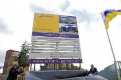 Gedeputeerde Mark Verheijen (rechts) en wethouder Pieter Meekels onthullen het bord dat uitbreiding van de haven van Holtum Noord aankondigt. Foto Ermindo Armino.