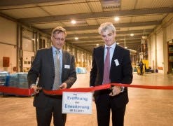 Met het doorknippen van een lint door Joep Mooren (links) en Frank Verhoeven werd gisteren de nieuwe magazijn uitbreiding van Vos Logistics in Goch officieel in gebruik genomen.