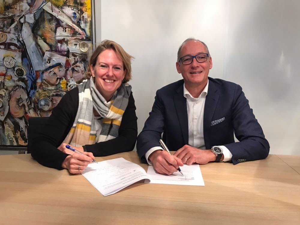 Esther Zumpolle van Eneco (links) en Jasper van Duuren (rechts) ondertekenen de overeenkomst voor 750 zonnepanelen.