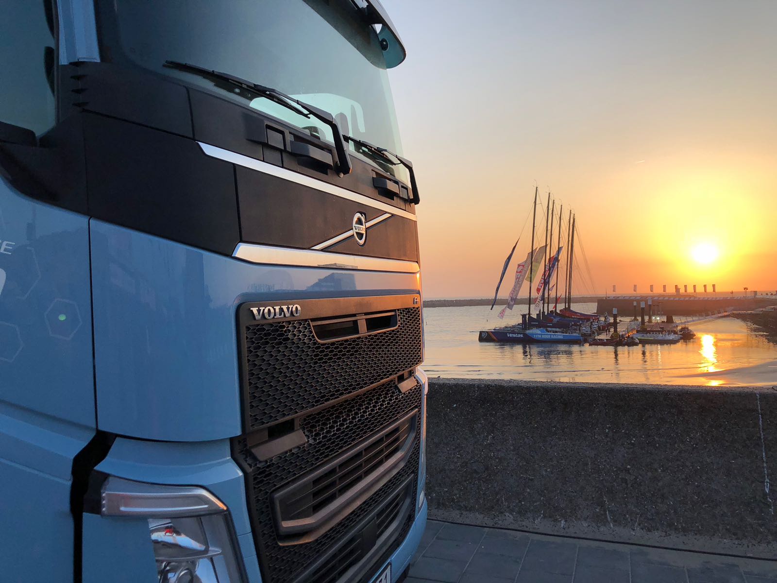 Een LNG truck van Volvo met op de achtergrond de zeven Volvo Ocean Race boten