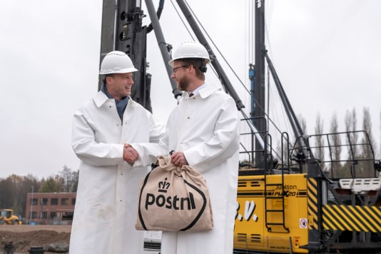 De Dordtse wethouder Maarten Burggraaf (rechts) en directeur strategie van pakketten & logistiek Coen Schut sloegen eind vorig week samen symbolisch de eerste paal van het nieuwe pakkettensorteercentrum dat augustus 2019 klaar moet zijn.