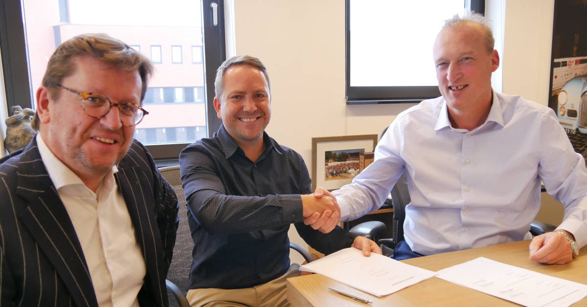 Meinderdjan Botman (links op de foto), chief commercial officer bij DSV Solutions en Piet van Dyk, general manager supply chain innovation bij DSV Solutions South Africa schudden de hand met Eric van Dijk (rechts), CEO bij Slimstock, om de partnerovereenkomst te bezegelen.