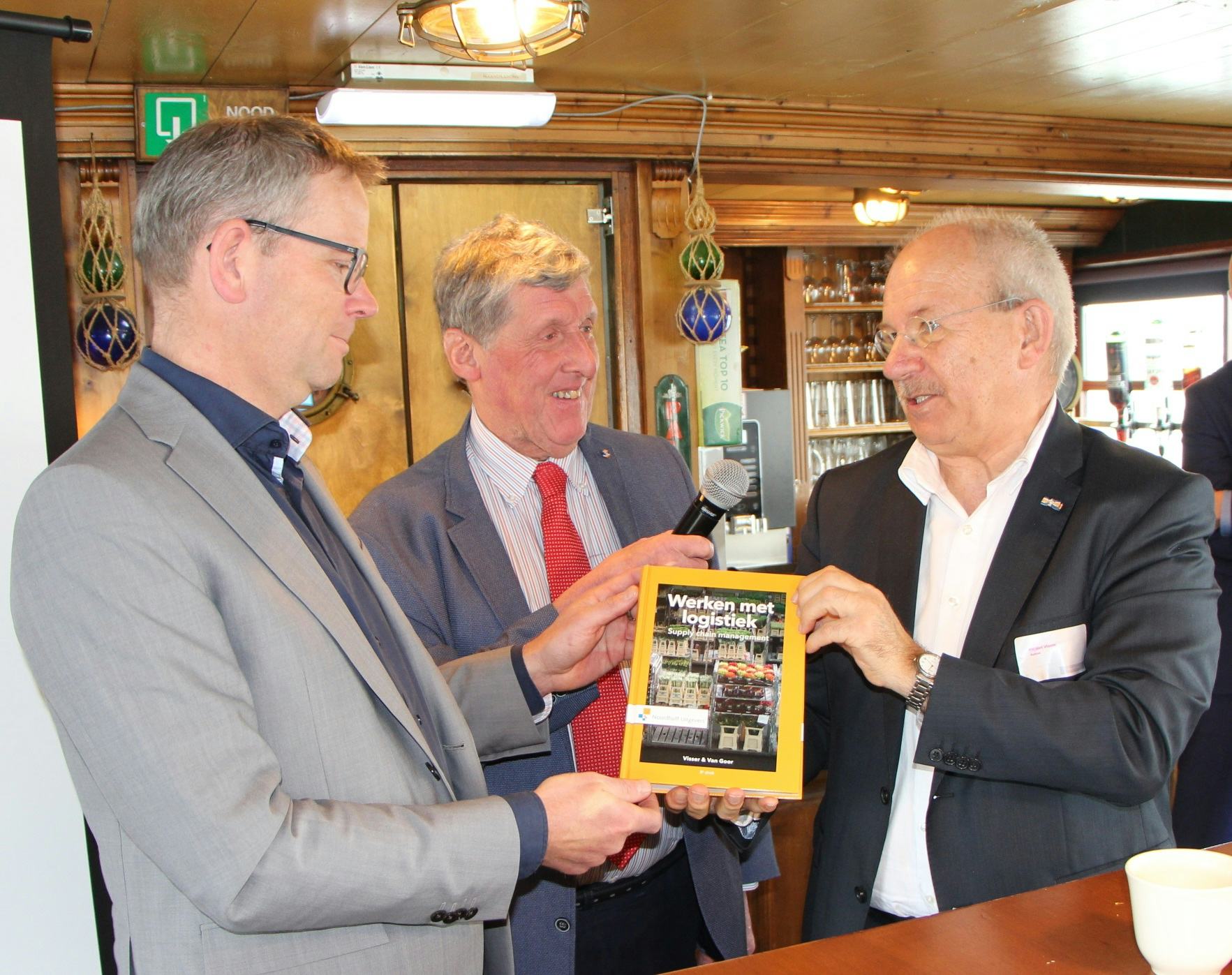 Ruud Limmen ontvangt uit handen van auteurs Ad van Goor en Hessel Visser het eerste exemplaar van het vernieuwde boek Werken met logistiek