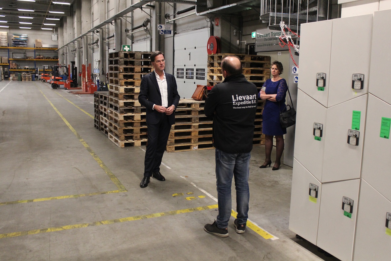 Minister-president Mark Rutte bracht een bezoek aan door corona getroffen transportondernemers. Samen met TLN-voorzitter Elisabeth Post luister hij naar een toelichting door een medewerker van het getroffen transportbedrijf Lievaart uit De Lier.