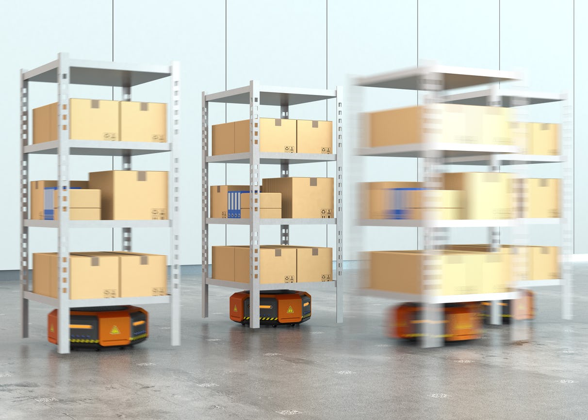 Oranje robots die pallets met goederen vervoeren in modern magazijn. 
