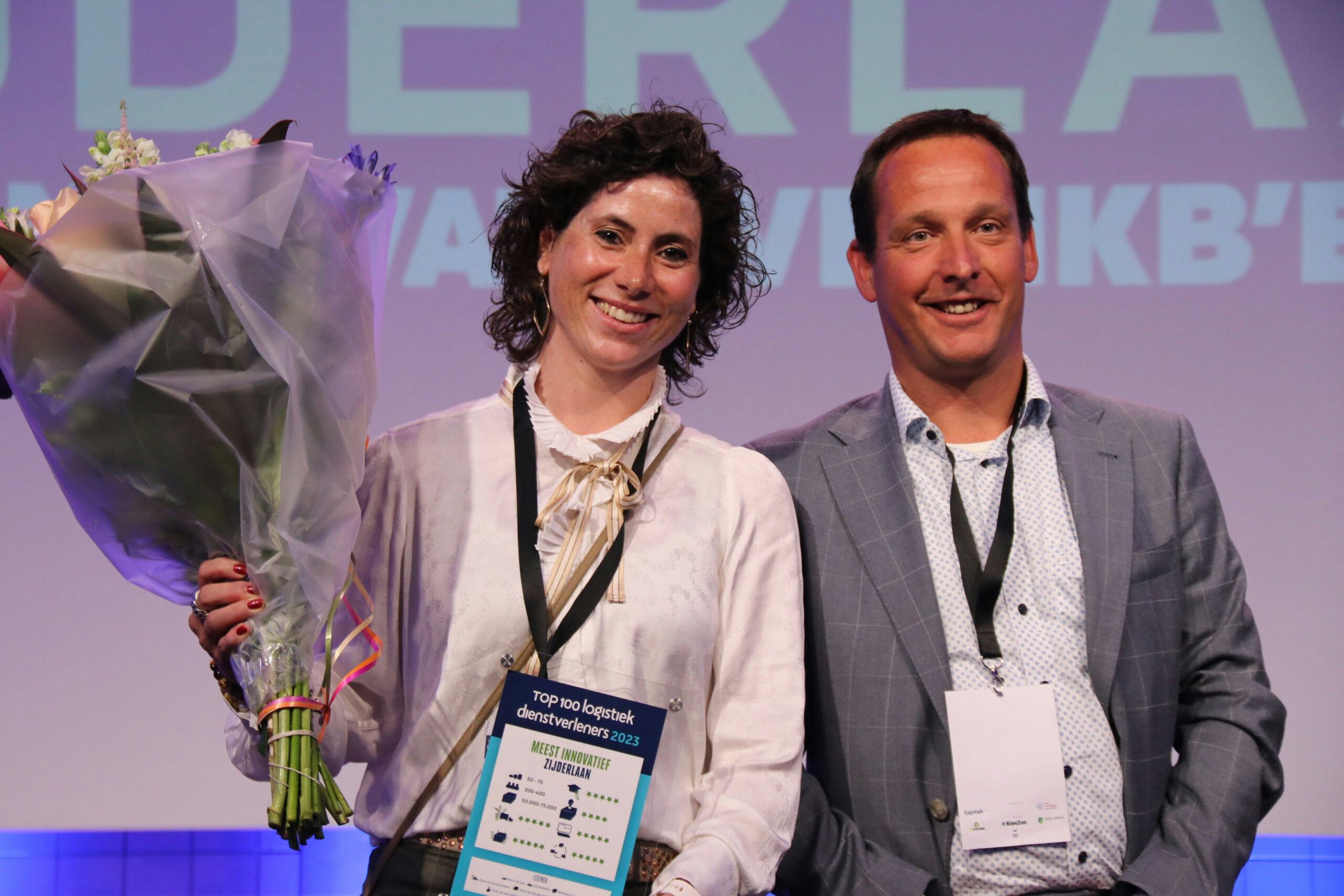 Sabine Zijderlaan en Leo Lokker nemen de award en bloemen in ontvangst als meest innovatieve mkb'er in de Top 100 Logistiek Dienstverleners 2023.