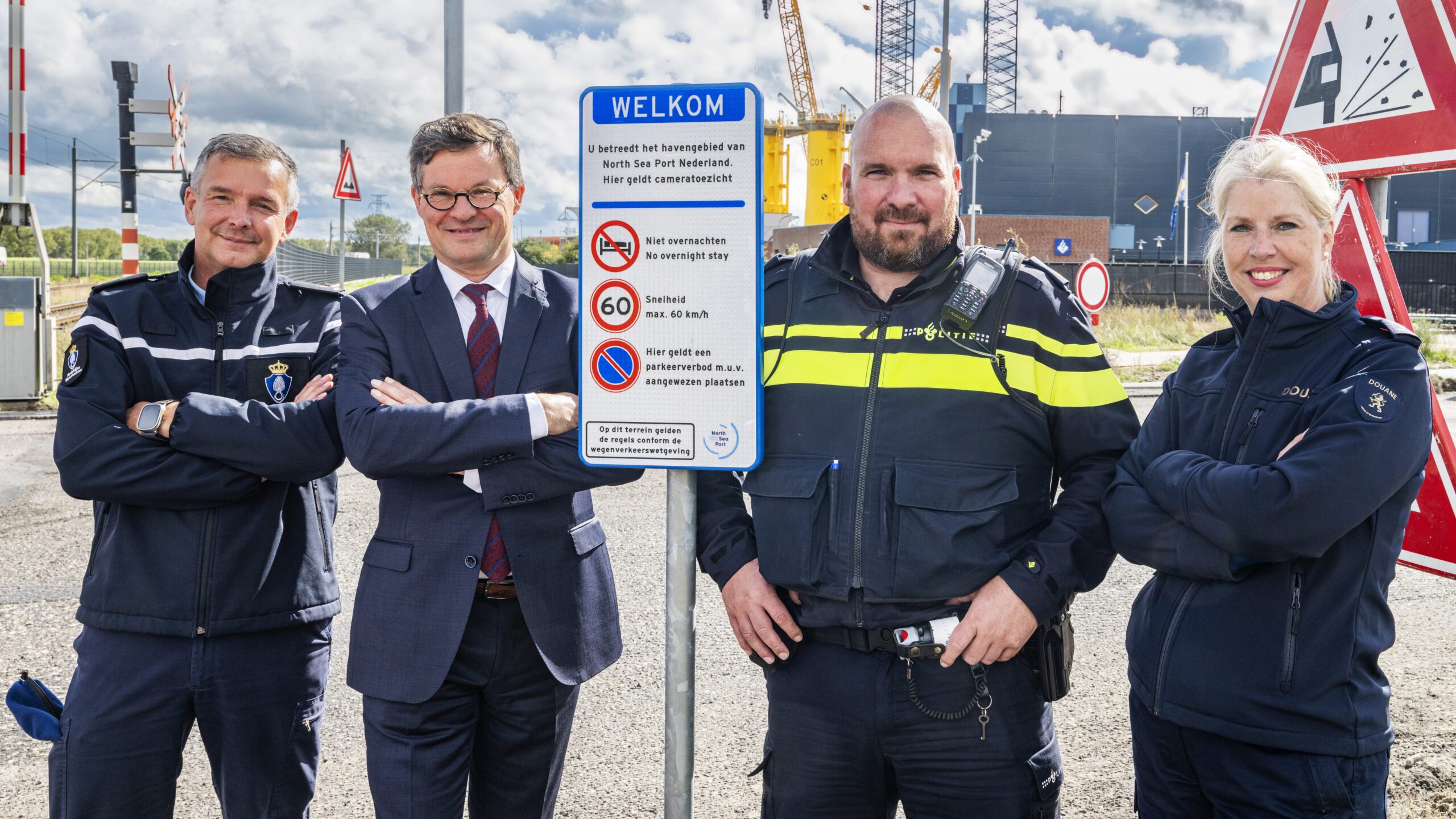 Burgemeester Bas van den Tillaar onthult een informatiebord bij het nieuwe 'slimme' hekwerk in de haven van Vlissingen.