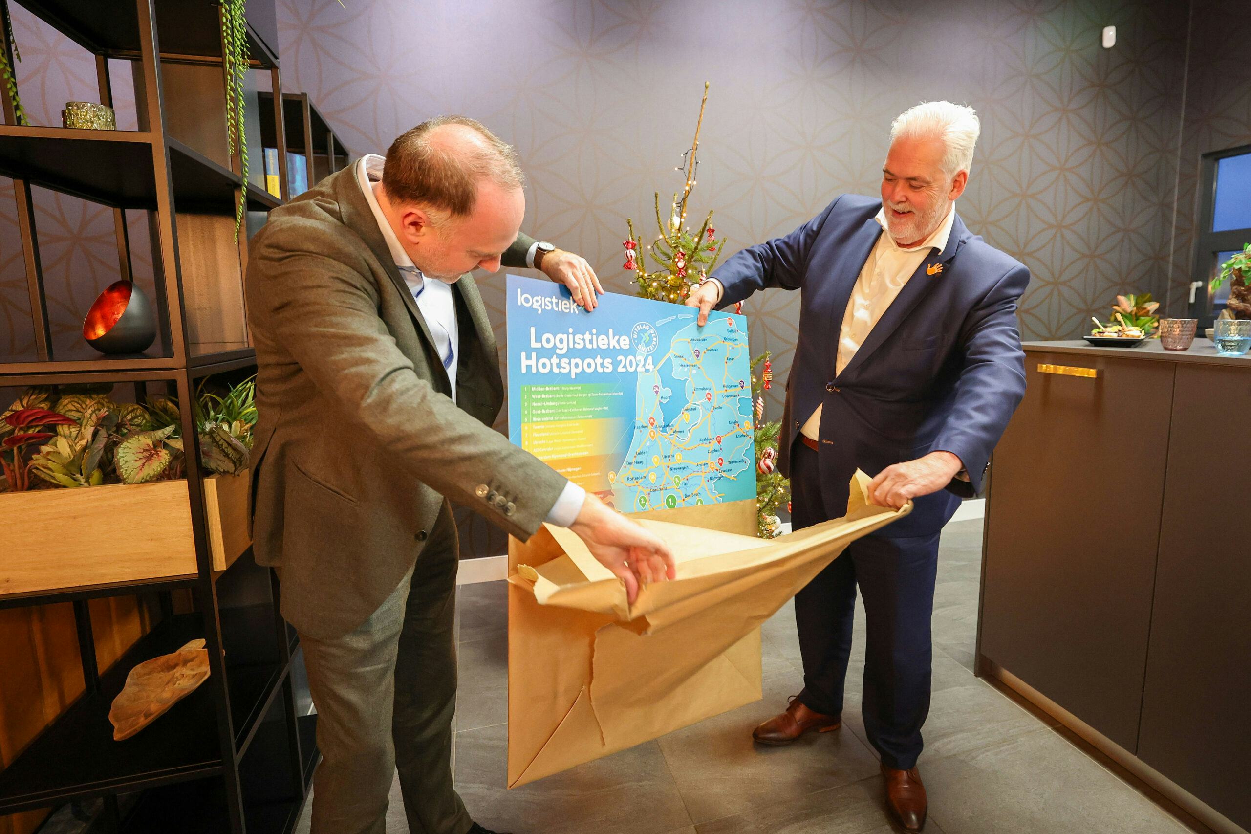 Wethouders Bas van der Pol van de gemeente Tilburg (links) en Frank Spierings van de gemeente Waalwijk (rechts) onthulden de uitslag van de verkiezing Logistieke Hotspots 2024. (Foto: Bert Jansen)