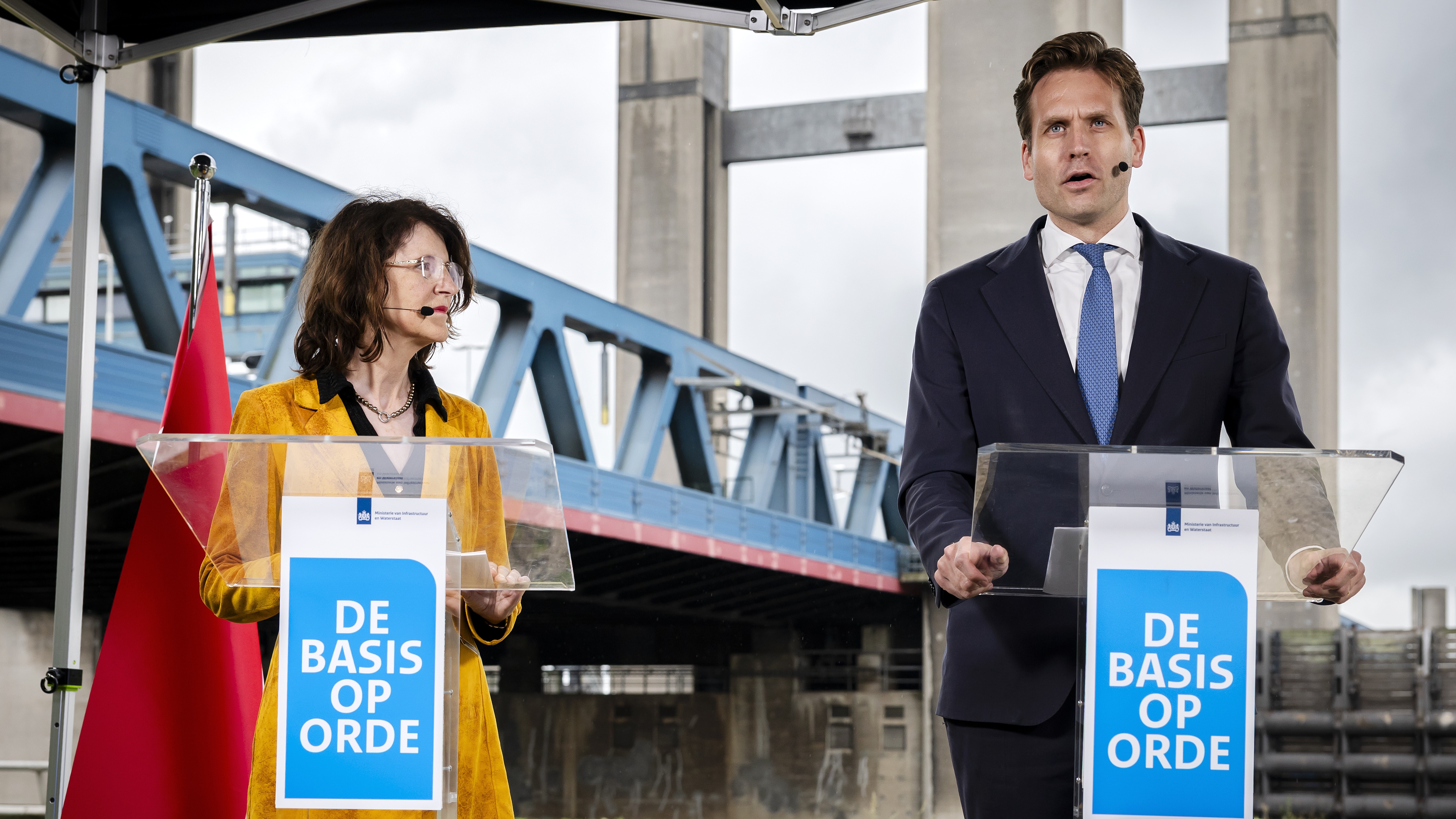 Minister Vincent Karremans (rechts) en staatssecretaris Annet Bertram (Infrastructuur en Waterstaat) presenteren bij de Calandbrug in Rotterdam de 'herprioritering van alle infrastructurele projecten'. Foto: ANP (Remko de Waal)